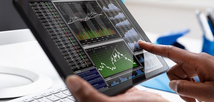 Close-up Of A Businessperson Pointing On Stock Chart Over The Tablet Screen