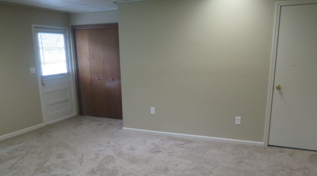 interior room of home with light tan walls and white trim and light colored carpet