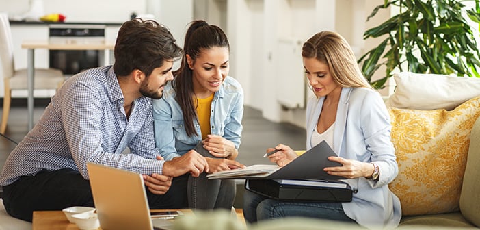 a couple going over business documents in a living room with an agent