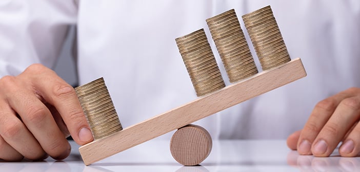 businessperson showing unbalance between stacked coins