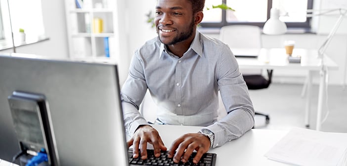 man sitting at desk working on a computer