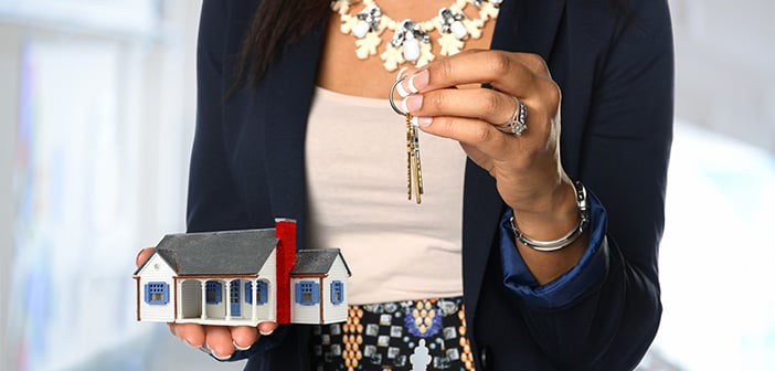 Female real estate agent holding house and keys