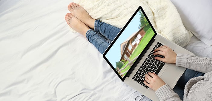 Man looking up real estate listings on laptop