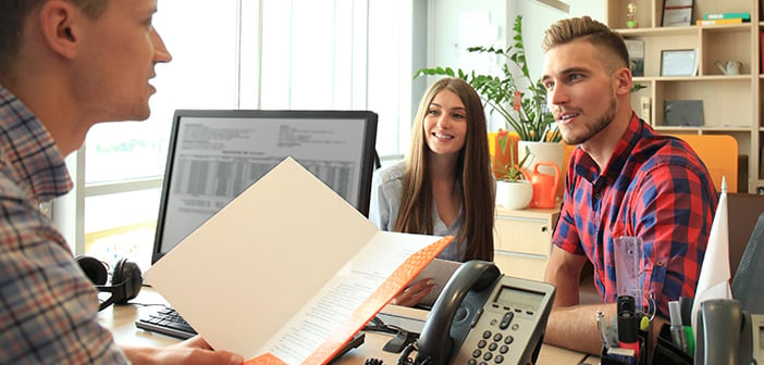 happy family at desk signing papers with real estate agent