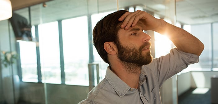 Sad businessman leaning on glass