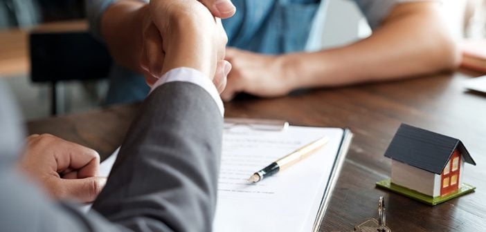 Estate agent shaking hands with his customer after contract signature