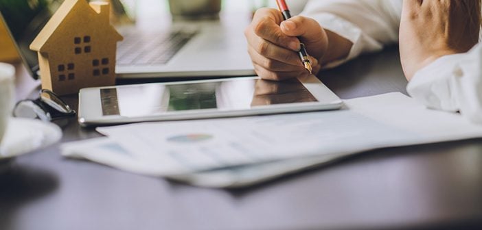 Hand of Business people calculating interest, taxes and profits to invest in real estate and home buying