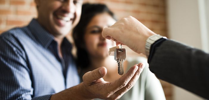 Cheerful couple receiving keys to their new home