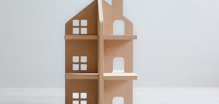 wooden model of multifamily property on gray background