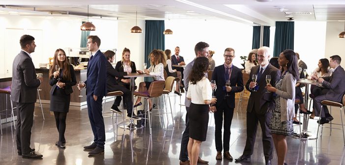 Business people networking and having cocktails at meetup in conference room setting