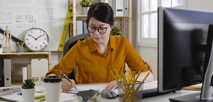 profesional joven mujer asiática arquitecto vistiendo camisa casual sentado en una acogedora oficina y hacer bocetos arquitectónicos. Concepto de profesión. Hermosa joven diseñador de interiores dibujo plano.