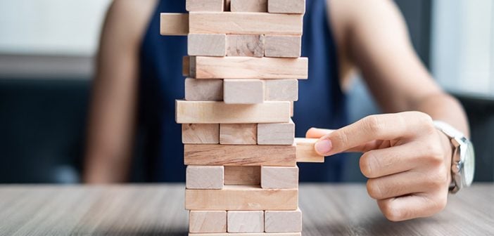 Businesswoman hand placing or pulling wooden block on the tower. Business planning, Risk Management, Solution and strategy Concepts