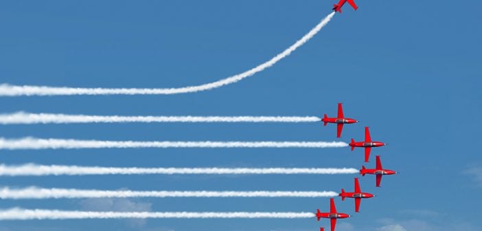 Charting a different path business concept as an independent free thinker idea with air show jet airplanes in an organized formation with one individual plane setting a new course with 3D illustration elements.