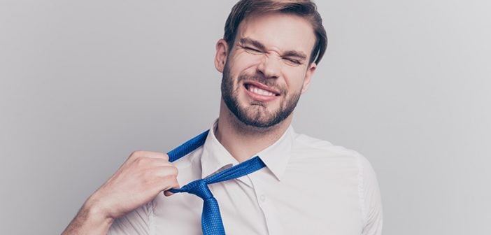 Close up portrait of exhausted frustrated stressed handsome sad unhappy upset entrepreneur trying to take off uncomfortable blue tie formal wear isolated on gray background copy-space