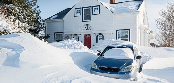 The snow is swirling around a family home snowed in after a snow storm.