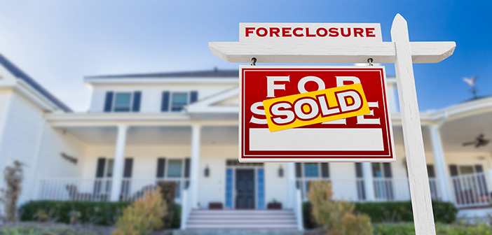 Foreclosure Sold For Sale Real Estate Sign in Front of House.