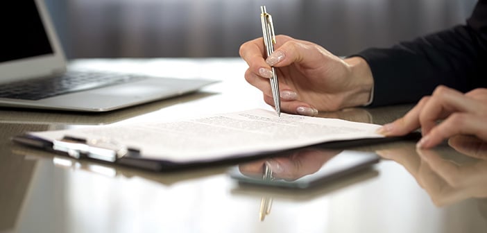 Woman in suit reading terms and conditions of agreement, signing contract, stock footage