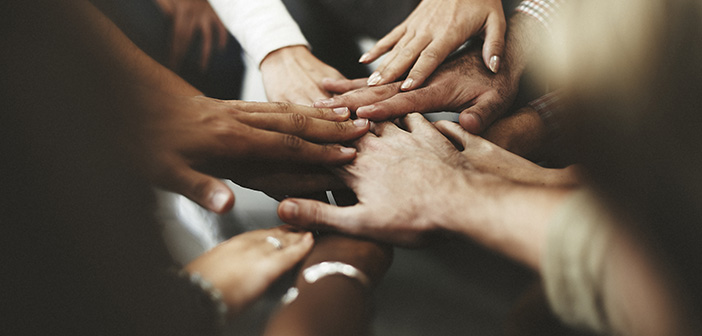 People with joined hands as a team