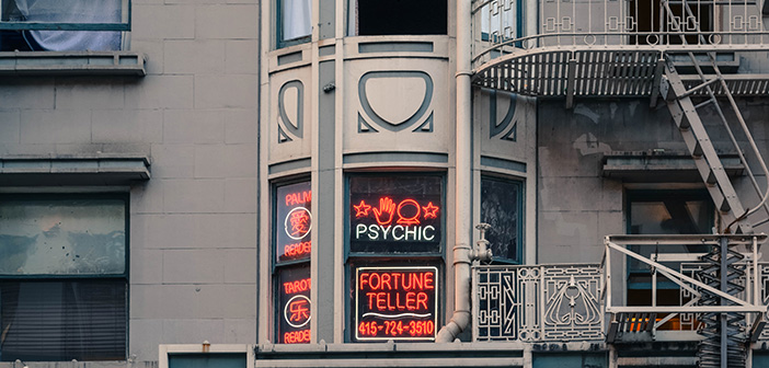 tan mixed use building with neon sign advertising psychic and fortune telling