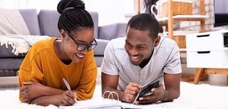 Young Couple Lying On Carpet Invoice With Calculator