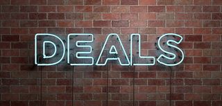 fluorescent neon sign reads deals on brick wall