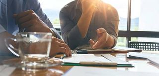 business colleagues meeting in boardroom going over paperwork