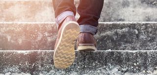 man with blue geans and sneaker shoes in stair