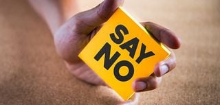 close up of hand holding yellow post-it reading say no