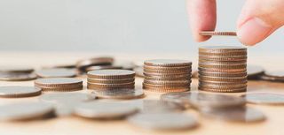 close up of hand stacking quarters in various piles