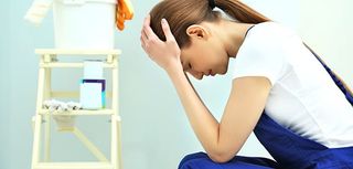 Young female decorator in empty room